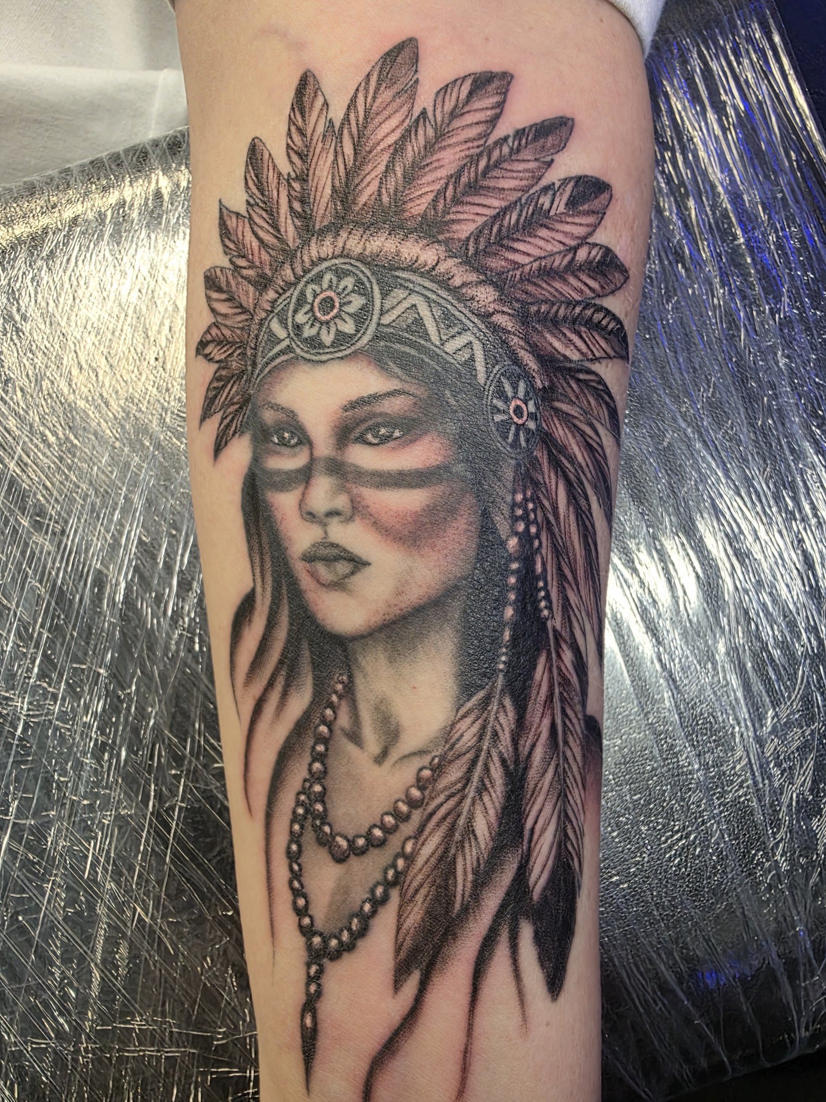 Black and grey portrait tattoo with feather headdress by Social Suicide Tattoos in Pahrump, Nevada