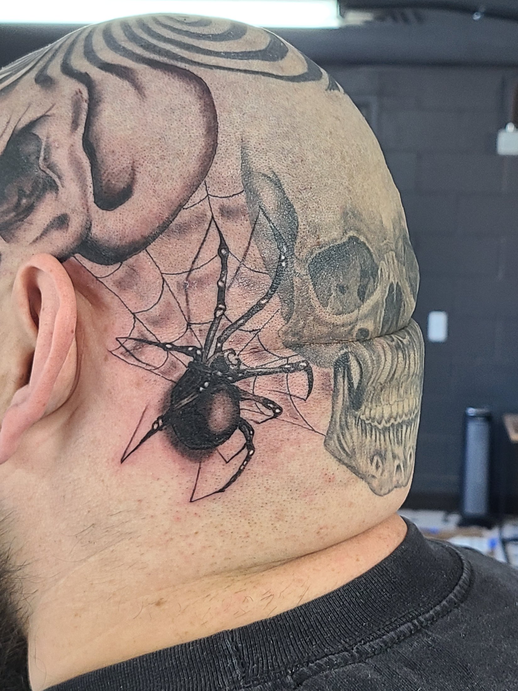Black and grey head tattoo with spider web by Social Suicide Tattoos in Pahrump, Nevada